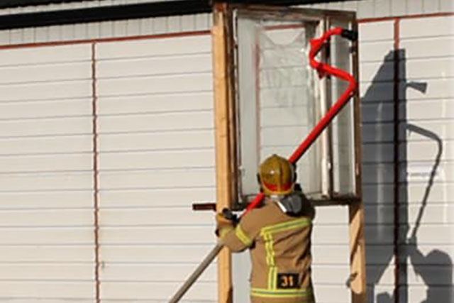 Palomies demonstroi ikkunalasin rikkomista tuotteella.