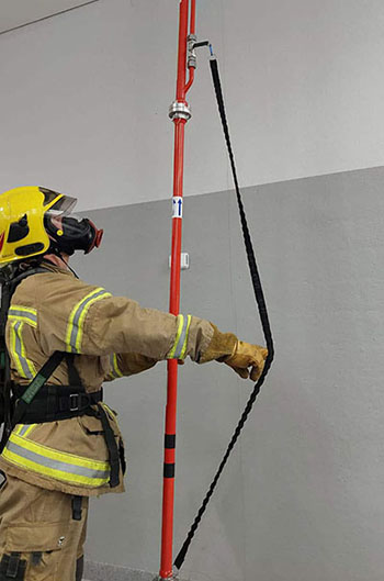 Varusteisiin pukeutunut palomies pitää kiinni tuotteen sammutusventtiilin hihnasta.